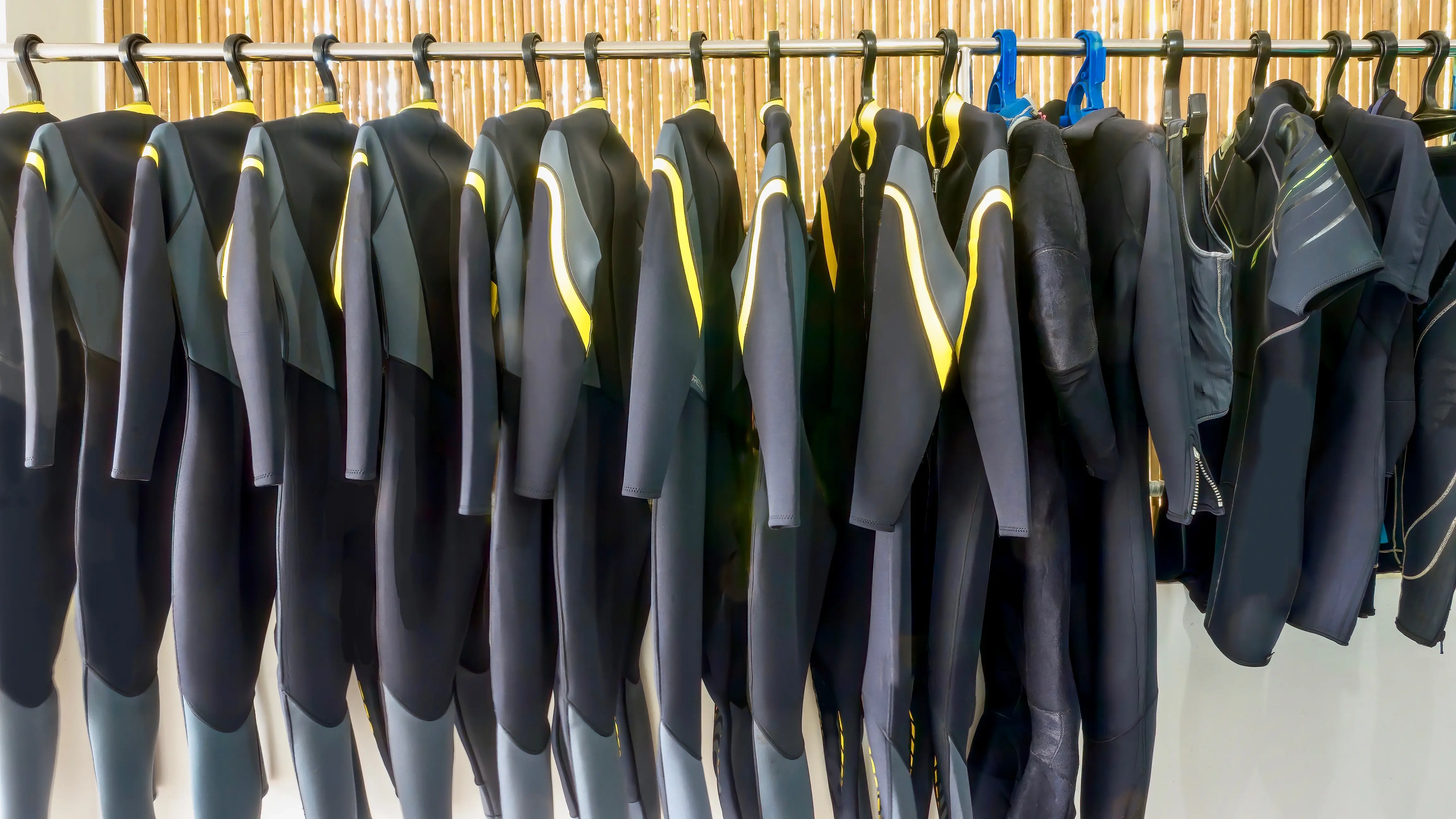 wetsuit inventory hanging in dive shop